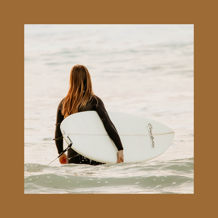 woman on beach sitting by a fire