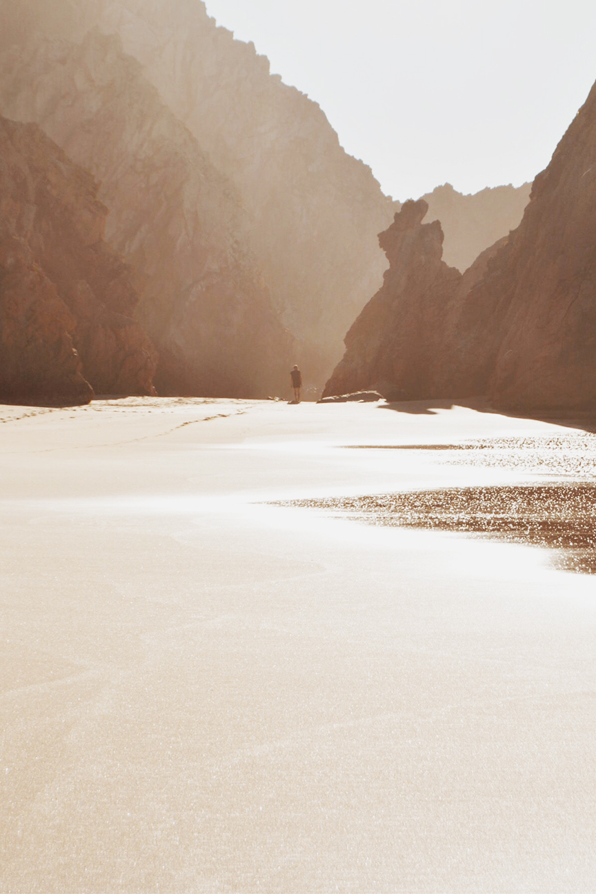 person standing in front of haystack rock in cannon beach oregon